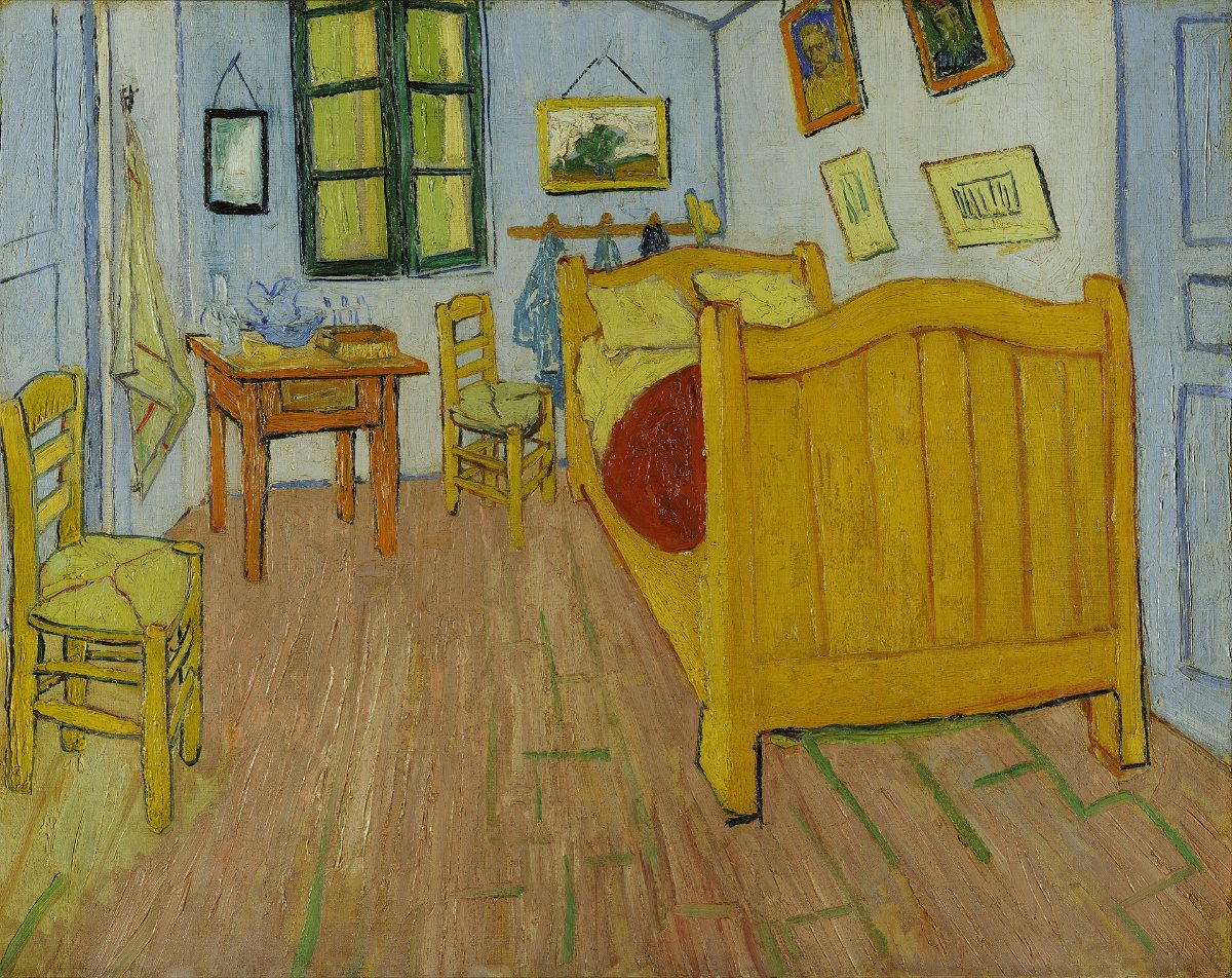 Vincent van Gogh's The Bedroom: a small room with a wooden bed, two chairs, a table, framed pictures on blue-toned walls, and a red-brown floor.